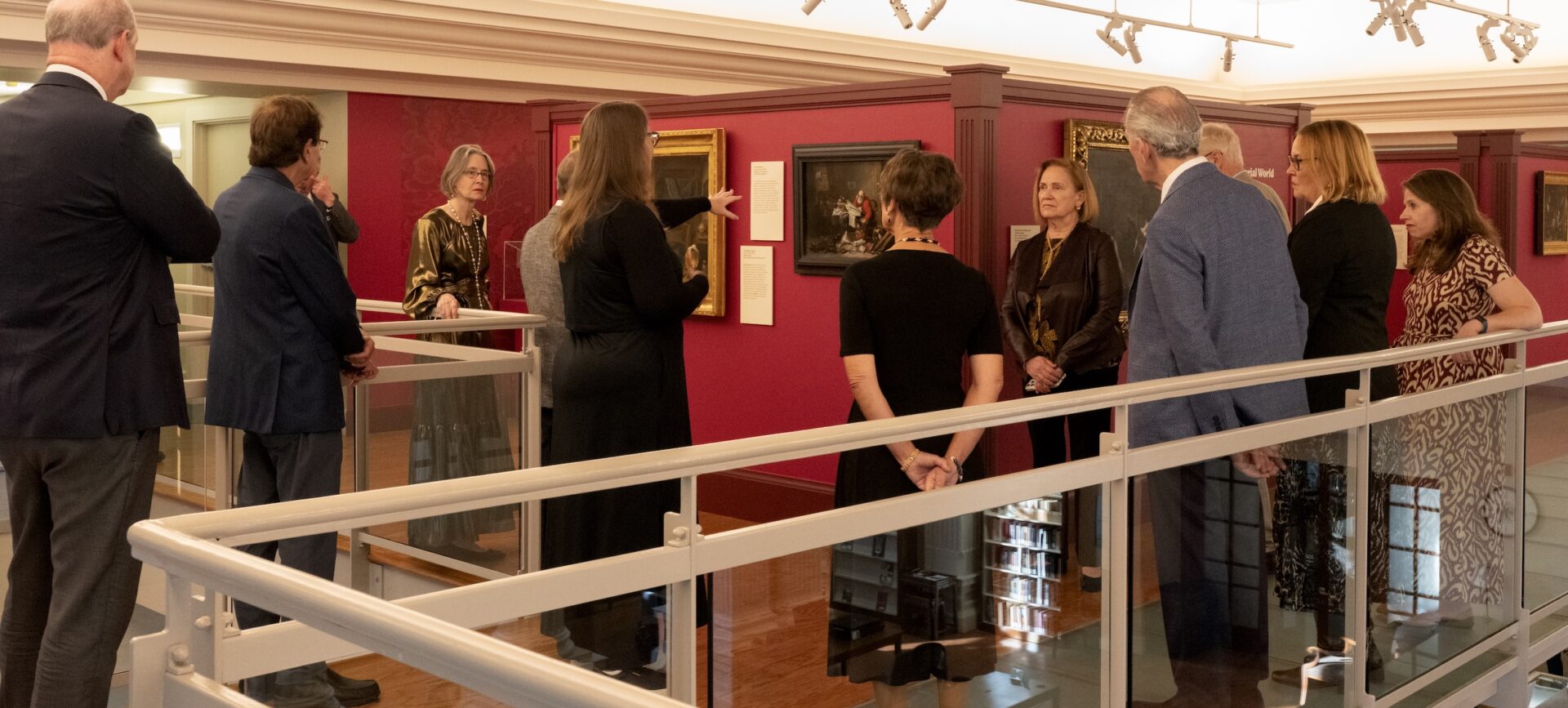 People gathered in a museum looking at paintings