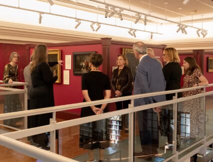 People gathered in a museum looking at paintings