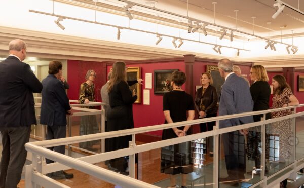 People gathered in a museum looking at paintings