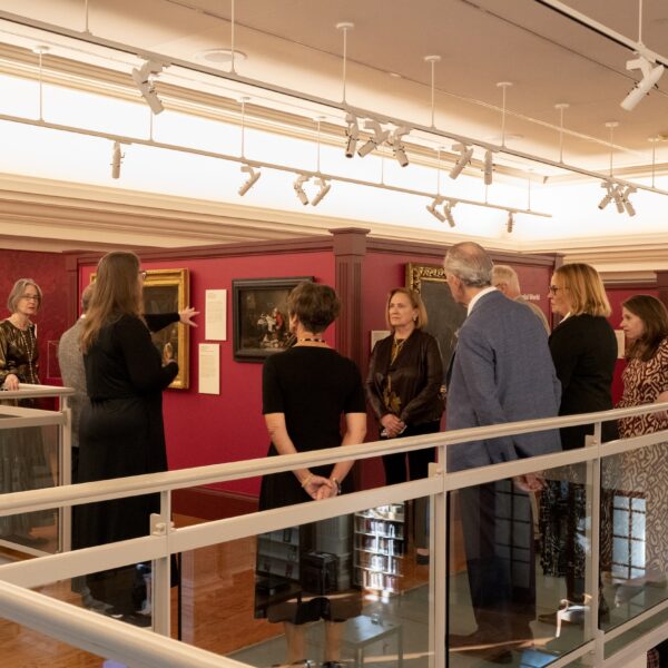 People gathered in a museum looking at paintings