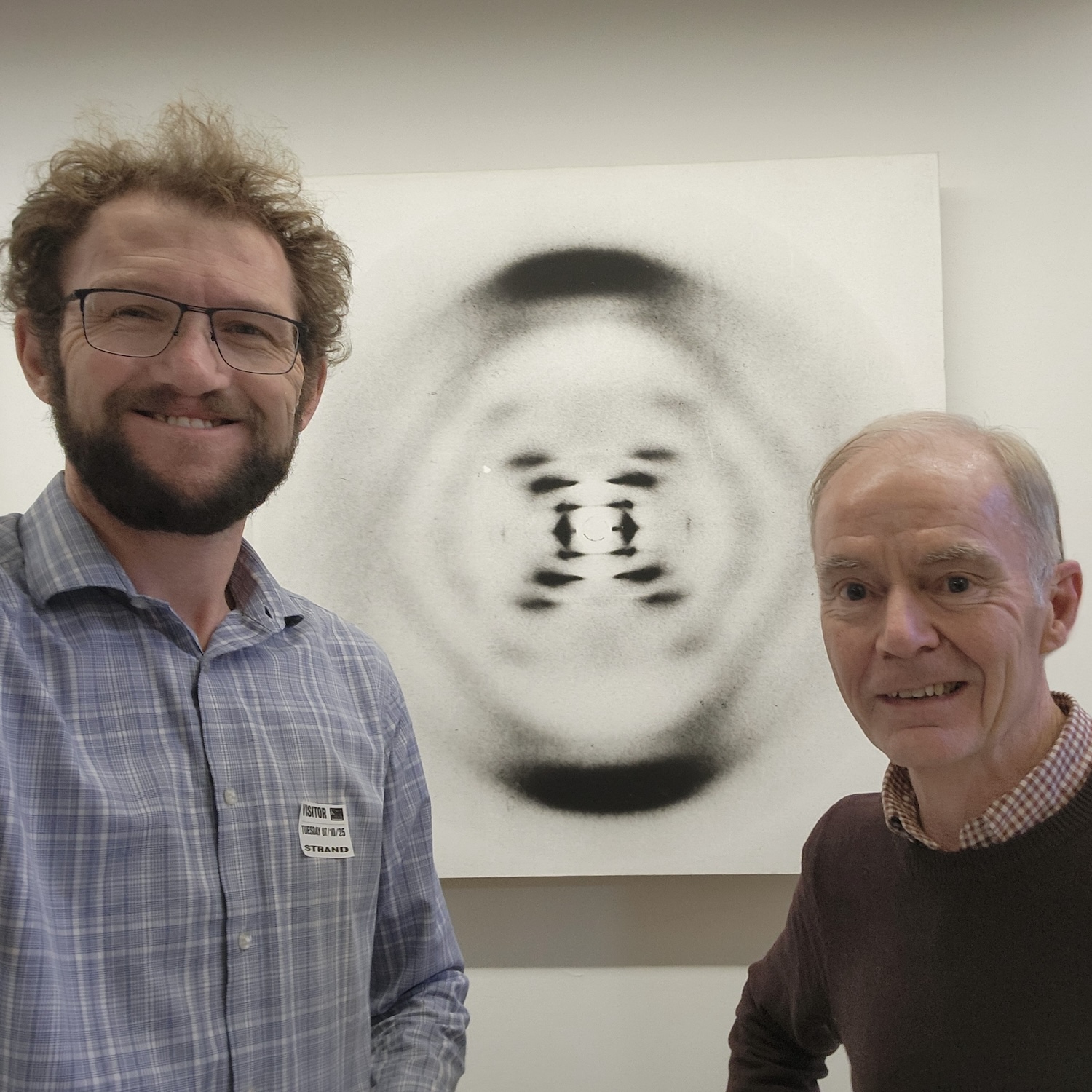 2 men standing in front of an image of Photo 51