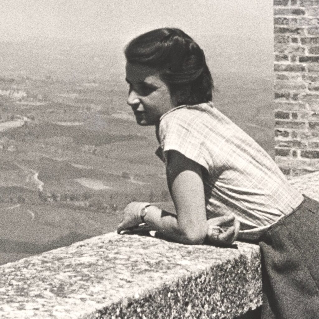 woman leaning over a balcony overlooking the countryside